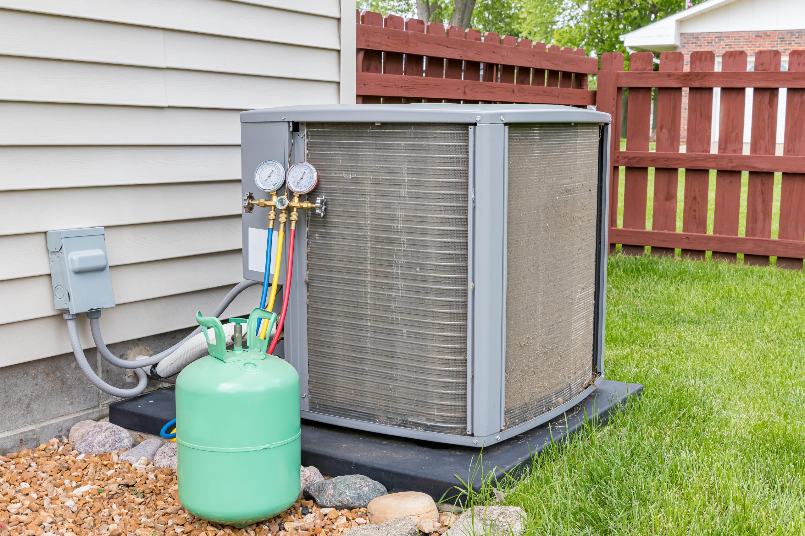 An outdoor air conditioning unit in need of DIY maintenance installed beside a home in Dallas, TX.